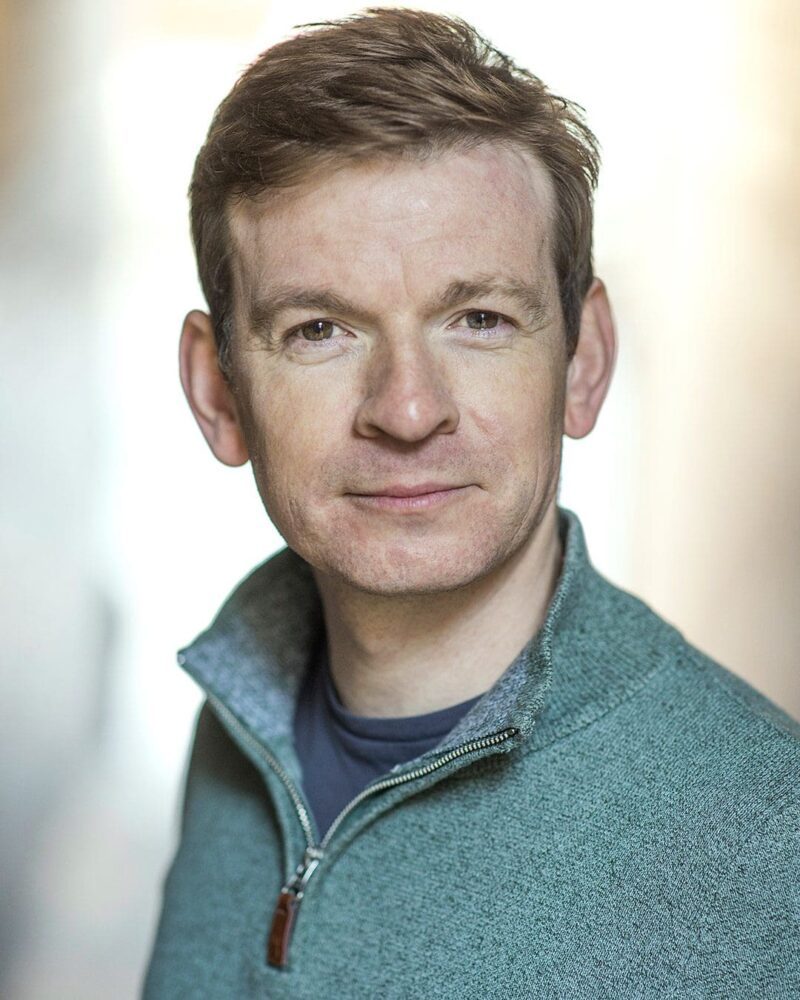 Warm natural light outdoor headshot of actor Dominic Hecht