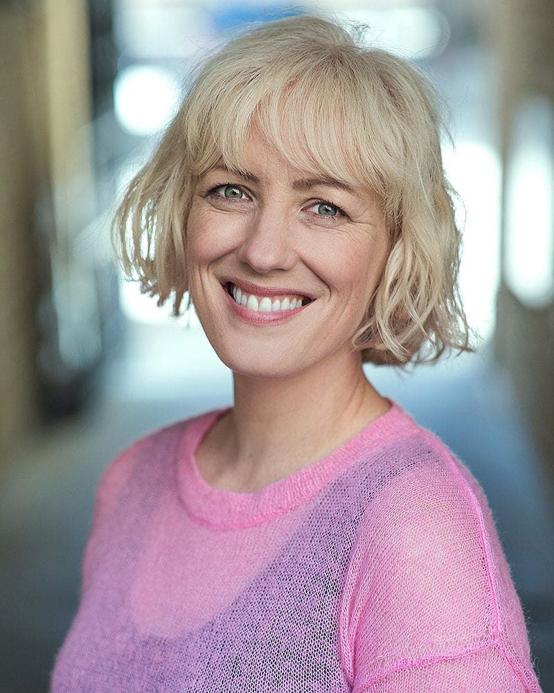 Smiley outdoor headshot of writer and actress Lisa Cassidy taken by London headshot photographer Remy Hunter