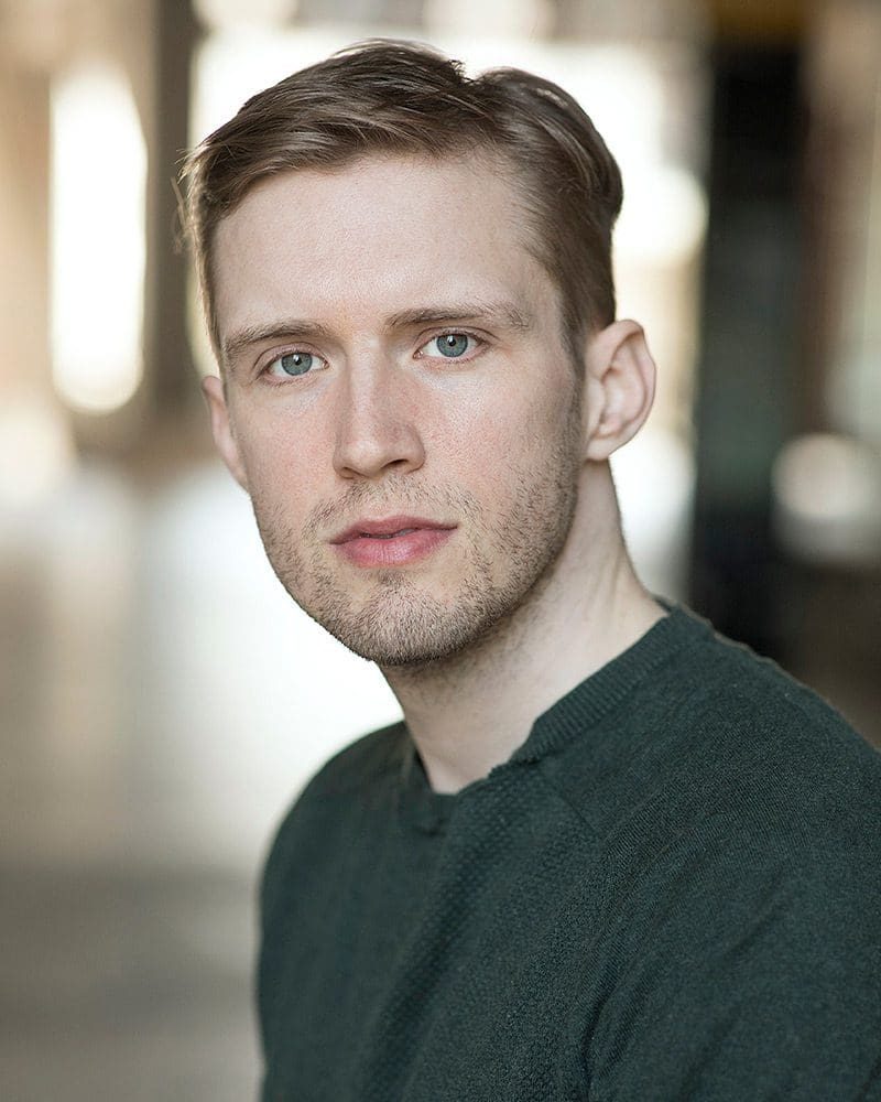 Natural light professional actor headshots of Thomas Langley wearing a green jumper